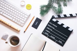 Can I Use Copyrighted Materials in My Business? Image includes a keyboard and movie clapboard on desktop
