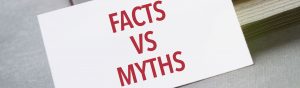 card that says facts vs myths in red on top of stack of books for article by kelley way three common myths about estate planning