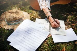 woman writing down lyrics used in article about estate planning for musicians by attorney kelley a way