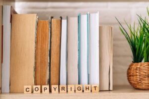 word copyright made of wooden tiles in front of books as featured image in article by kelley way titled when do copyrights expire