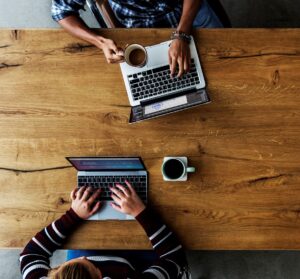 Colleagues sitting together working on their laptops is the featured image for the blog article by kelley way titled Who Owns the Copyright