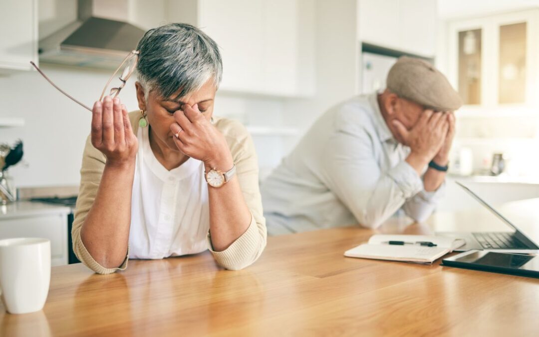 frustrated senior couple at table, holding their heads in their hands is the featured image for the article by kelley way titled